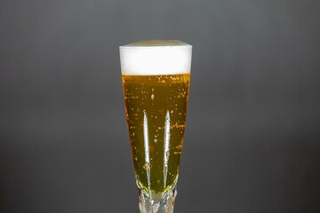 Cold beer dripping foam into glass