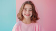 Young cheerful girl wearing pink shirt on the pastel background.