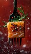 b'A cube of raw salmon fillet on a fork with rosemary and peppercorns against a red background'