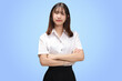 Portrait Asian student girl with Thai university uniform cross arms isolated on blue background.