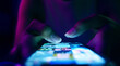 Finger of woman touching scroll page app on mobile phone.In a room with blue and purple neon tones.concept Social Media, Marketing, Post - Structure, Image-based Social Media, like buttons