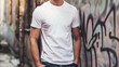 © Kanlayarawit - Mockup of clothes worn by a model. Close up of full upper body part from hip to neck on plain background. A man wearing a basic white t-shirt on a city background.