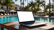 Laptop with a blank white screen mock up on table in tropical hotel with palm trees on swimming pool on trip. Remote work on vacation and travel, home office, internet, tours, resort