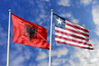 3d illustration. Albania and  Liberia Flag waving in sky. High detailed waving flag. 3D render. Waving in sky. Flags fluttered in the cloudy sky.