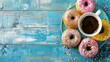 Coffee cup and colorful donuts on wooden blue background