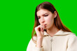 Young Woman Contemplating Deeply Against a Vibrant Green Background