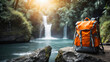 © Ольга Симонова - Orange hiking backpack on the background of a waterfall in the rainforest. Travel, trekking tour to wild, exotic places, tourism, outdoor activities.