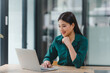 © kenchiro168 - Confident young asian business woman using laptop at modern office.