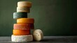 A stacked assortment of various types of cheese against a dark green background