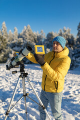 Wall Mural - amateur astronomer looking at the sun trough a telescope with special solar filter.