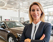 Professional businesswoman blonde arms crossed in interior cars dealership salon showroom for sell car