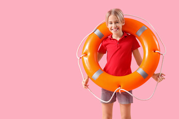 Wall Mural - Happy little boy lifeguard with ring buoy on pink background