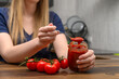 Koncentrat pomidorowy na łyżeczce obok świeżych pomidorów 