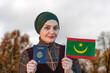 Muslim Woman Holding Passport and Flag of Mauritania

