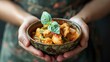 Hands holding a bowl of comforting curry stir-fry, offering a taste of Thailand's rich culinary heritage