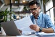 © SHI - A busy young professional businessman checks documents on his laptop in his office. Serious business accounting experts in the workplace read legal documents overview of company documents.