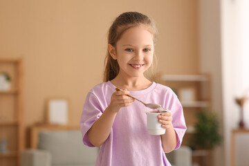 Poster - Cute smiling little girl eating yogurt at home