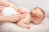 Fototapeta Perspektywa 3d - Little baby receiving chiropractic treatment of her back