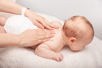 Wall Mural - Little baby receiving chiropractic treatment of her back