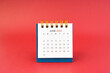 June 2024 white desk calendar on red background.