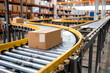 © Chebix - A conveyor belt in a warehouse with boxes on it.