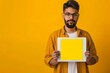 © Markus Schröder - Digital mockup indian man in his 20s holding a tablet with a completely yellow screen