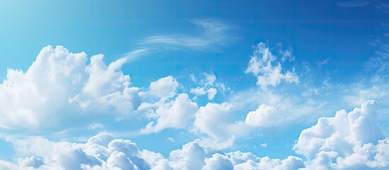 Poster - Fluffy white clouds float in a clear blue sky