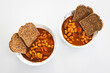 plant-based homemaed baked beans with butter beans and tempeh cubes in spicy tomato sauce served with grain bread