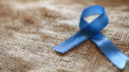 Blue ribbon pinned on a lapel raising awareness for autoimmune and autoinflammatory diseases on World Autoimmune Arthritis Day