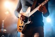 b'Close-up of an unrecognizable male guitarist playing the guitar on the stage during the concert'