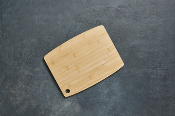 Wall Mural - Wooden cutting board on the decorative table, view from above, napkin, empty, textured background.