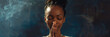African American woman prays to god on dark studio background. Cinematic effect