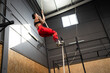 Woman training climbing a rope in a cross training center