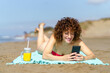 Happy woman with smartphone and juice on beach