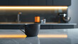 modern kitchen interior with elegant black cup on marble countertop, illuminated by warm lighting