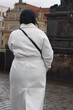 Woman in white coat in the city of Prague, Czech Republic