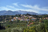 Fototapeta  - A town in the valley and rocky peaks in the Lefka Ori mountains on the island of Crete