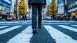 Confident businessman in suit briskly walking across city street crosswalk.