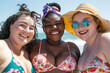 © igorfrost - Young diverse chubby women in swim suits laughing on beach, multiracial plus size girls of different skin colors and bodies, african caucaisian and hispanic big female friends smiling summer portrait