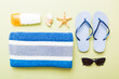 Summer holiday concept. Top view of beach towel, flip flop and sunscreen cream on table Top view with copy space for text