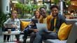 © NooPaew - Multicultural businesspeople working in an office lobby. Group of happy businesspeople smiling while sitting together in a co-working space. Young entrepreneurs collaborating on a new project.