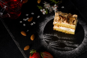 Wall Mural - Norwegian cake. With meringue, whipped cream and almonds. Dark background.