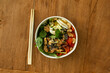 Top view of colorful bowl poke asian food with chopsticks