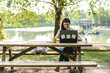 Freelancer working in nature's calm. Serene park setting enhances concentration and well-being. Woman at remote work.