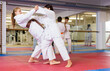 © JackF - Pair of teenager girls wearing kimono practicing new karate moves during training in gym