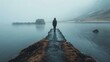 b'Lonely Man Standing on a Pier Overlooking a Misty Lake'