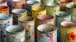 A set of candle holders created from empty tin cans coated in a layer of ceramic glaze and decorated with pressed flower imprints..
