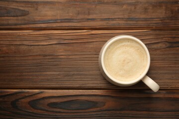 Poster - Cup of coffee on wooden table, top view. Space for text