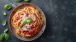 Tasty appetizing classic italian spaghetti pasta with tomato sauce, cheese parmesan and basil on plate on dark table, View from above, horizontal