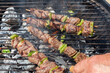 Turning beef brochettes on barbecue with a fork
